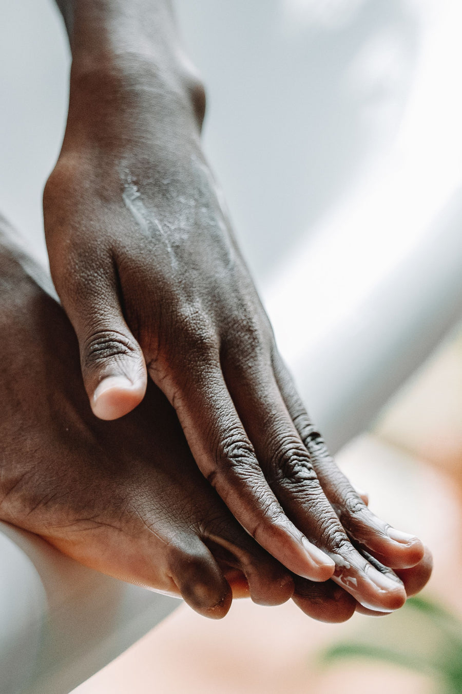 Hands smoothing lotion over a foot