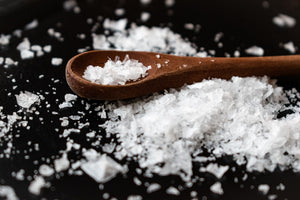 White mineral crystals on a wooden spoon